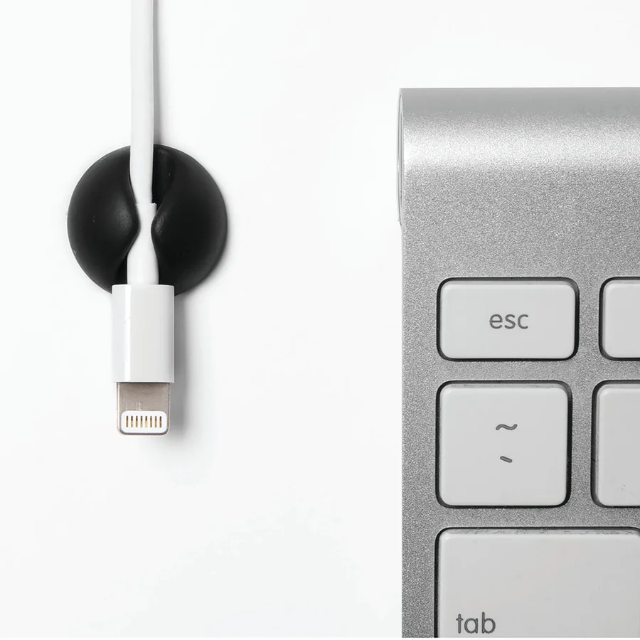 Black Bluelounge CableDrop Mini securing a charging cable beside a keyboard