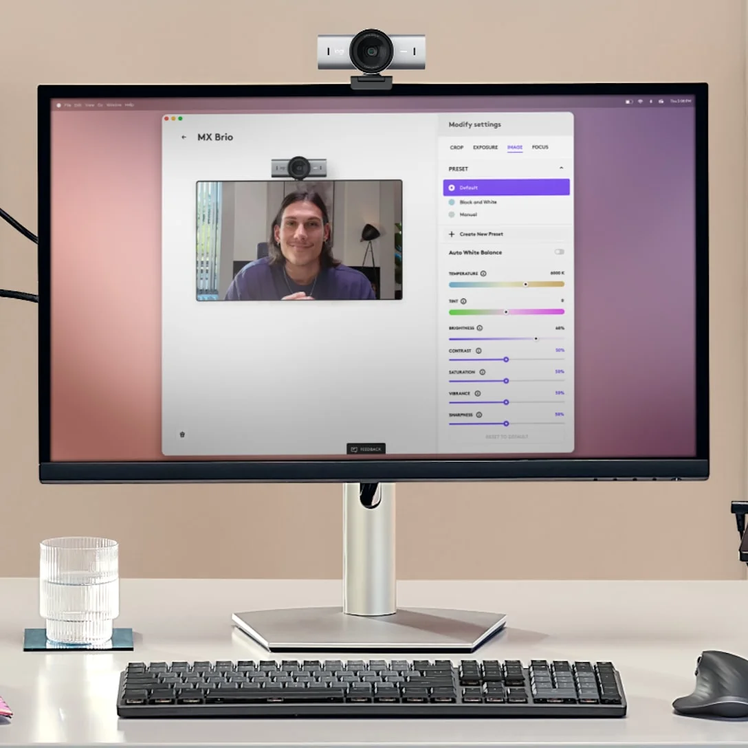 Logitech MX Brio webcam mounted above a monitor displaying camera settings